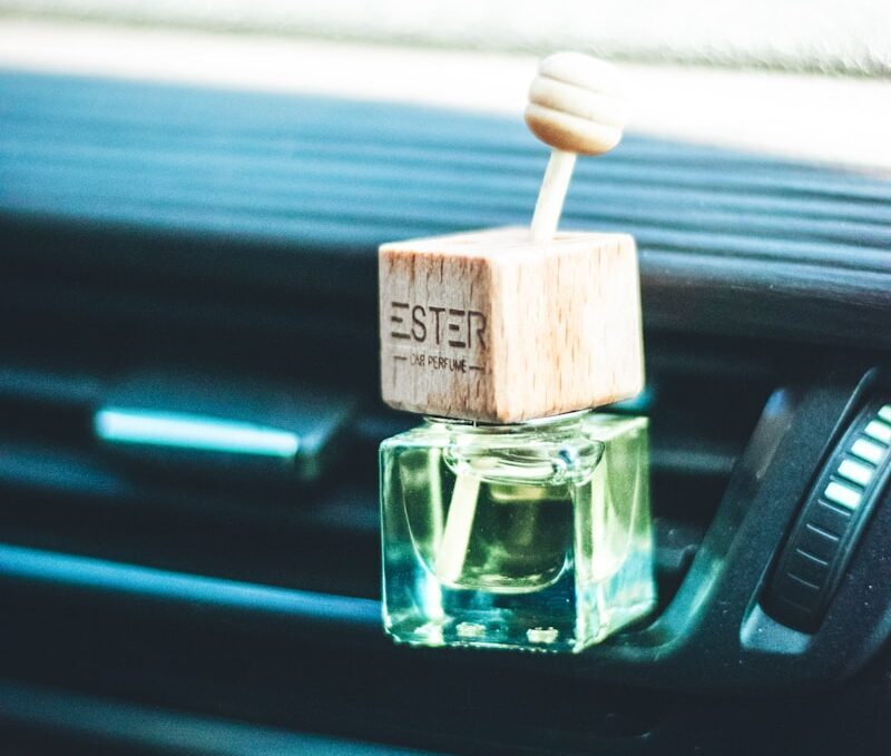 a small bottle of perfume sitting on the dash of a car